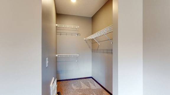 Walk in closet with plenty of shelving and hanging space in a furnished apartment at the conrad