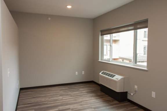 A room with a window and a wall hvac unit