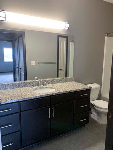 Spacious bathroom with tub shower and granite countertops in 1 bedroom apartment for rent at The Flats at 84 best apartments Lincoln NE 68516