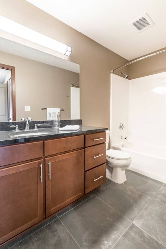 Bathroom with granite countertops and tile floors at The Flats at 84 in southeast Lincoln NE 68516