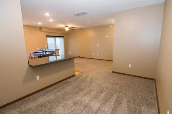 A spacious dining space or office with a carpeted floor and a window.