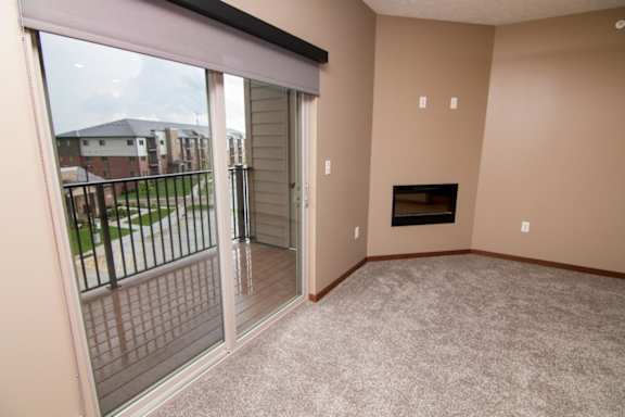 A living room with a fireplace and sliding glass doors to balcony