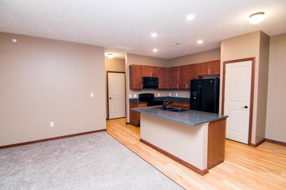 A kitchen area with an island and cabinets.