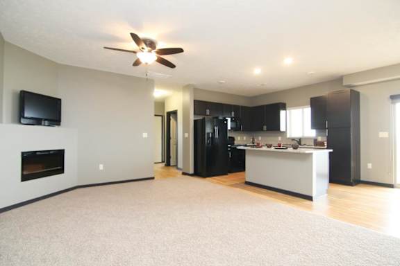 A spacious living room with a fireplace and a television.