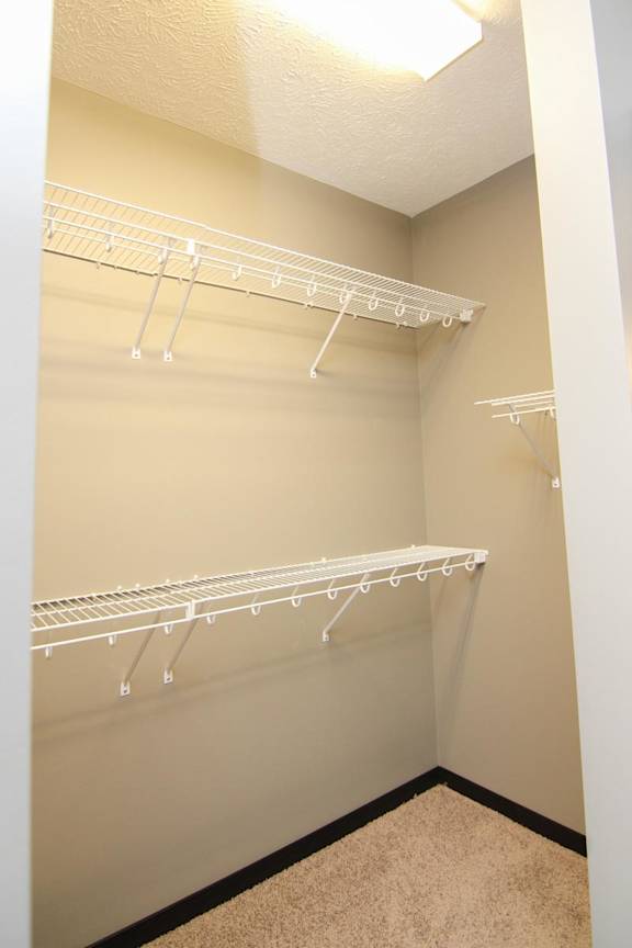 Empty white shelves in a walk-in closet.