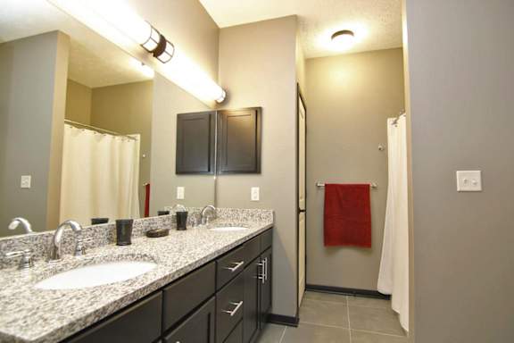 A bathroom with a sink, mirror, and cabinets.