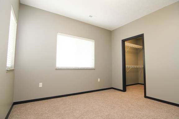 A room with a window and a closet.
