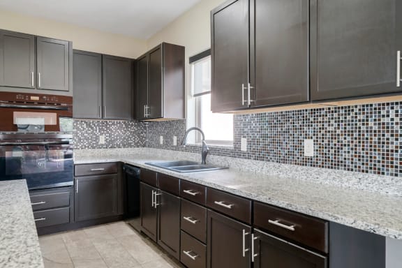 clubhouse kitchen with dark cabinets and granite countertops