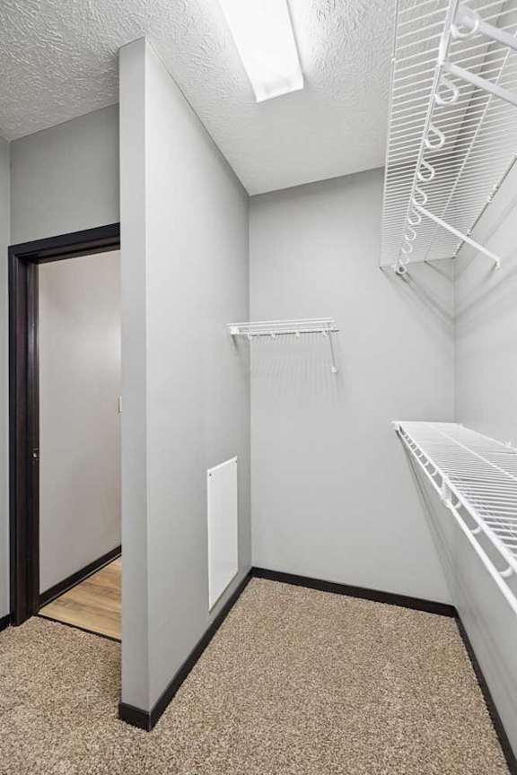 An oversized walk-in closet with several built-in wire shelves.