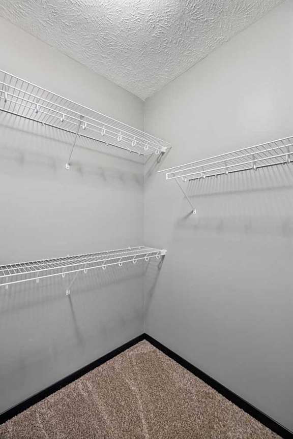 A walk-in closet with built-in wire shelves.