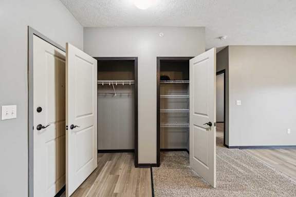 A hallway closet next to a pantry with several shelves.