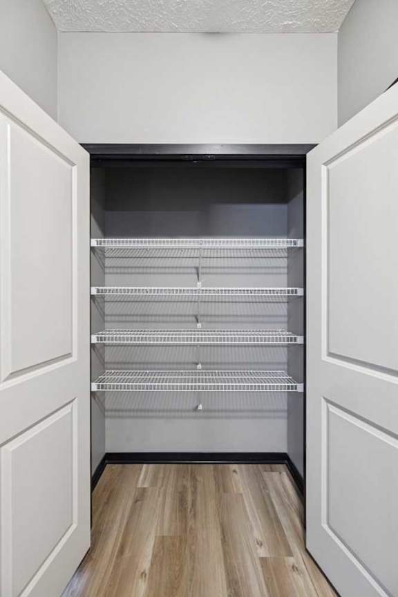 A double door linen closet with several built-in shelves.