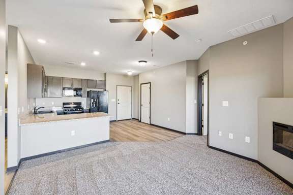 A spacious kitchen with a ceiling fan and a fireplace.