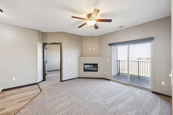 A spacious living room with a fireplace and sliding glass doors.