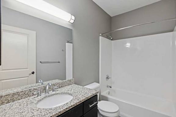 A bathroom with a sink, toilet, and bathtub.