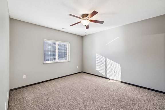 A room with a ceiling fan and a window.