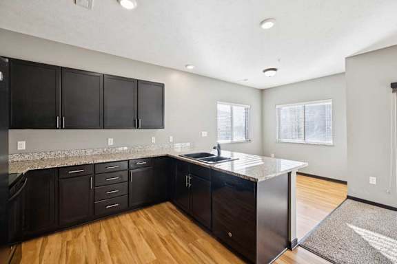 A kitchen with black cabinets and a granite countertop.
