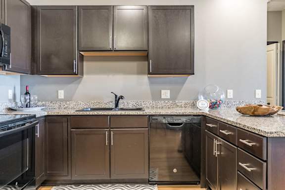 Style A design with dark cabinetry and light granite countertops
