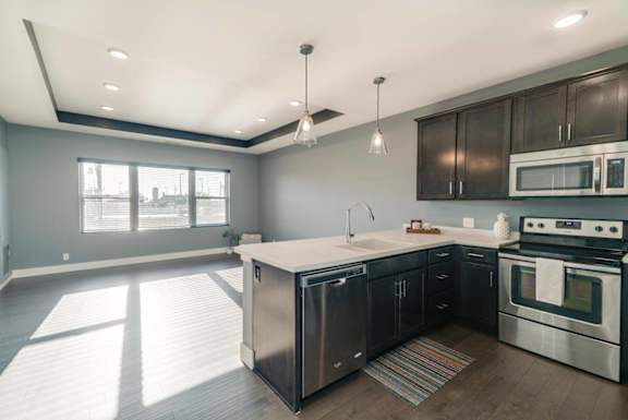 A modern kitchen with stainless steel appliances and wooden cabinets.