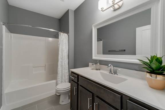 A bathroom with a white tub, sink, and toilet.