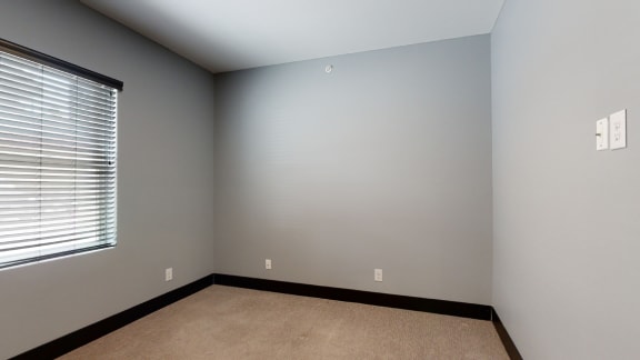 a bedroom with gray walls and a window