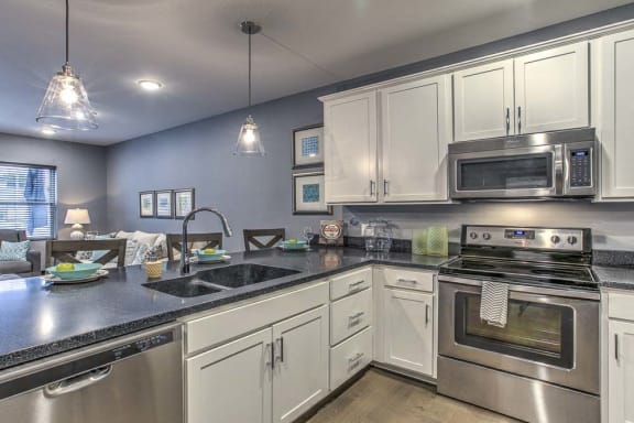 Large open floor plan kitchen with white cabinetry and stainless steel appliances