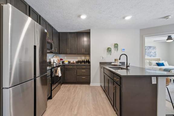 Modern apartment kitchen with island and stainless steel appliances.