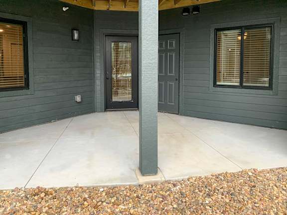 dark gray exterior of building with concrete patio