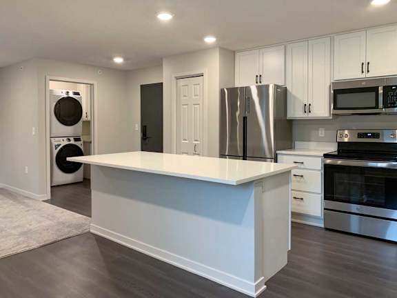 modern kitchen with stainless steel appliances and white cabinets.