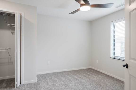 The primary bedroom in the Dove featuring a window and ceiling fan