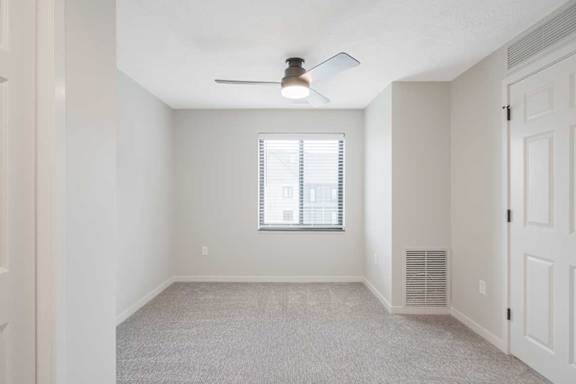 The primary bedroom in the Dove featuring a window and ceiling fan