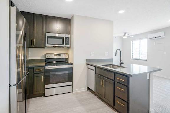 a kitchen with stainless steel appliances and dark wooden cabinets