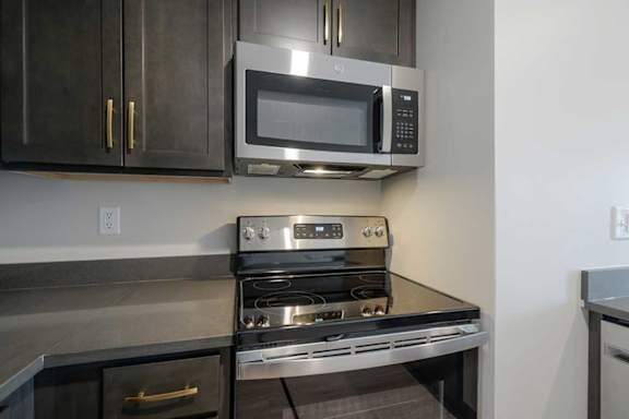 a kitchen with a stainless steel microwave and glass stovetop