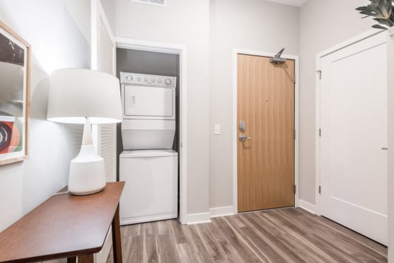 entry way with door to hallway and closet with stacked laundry