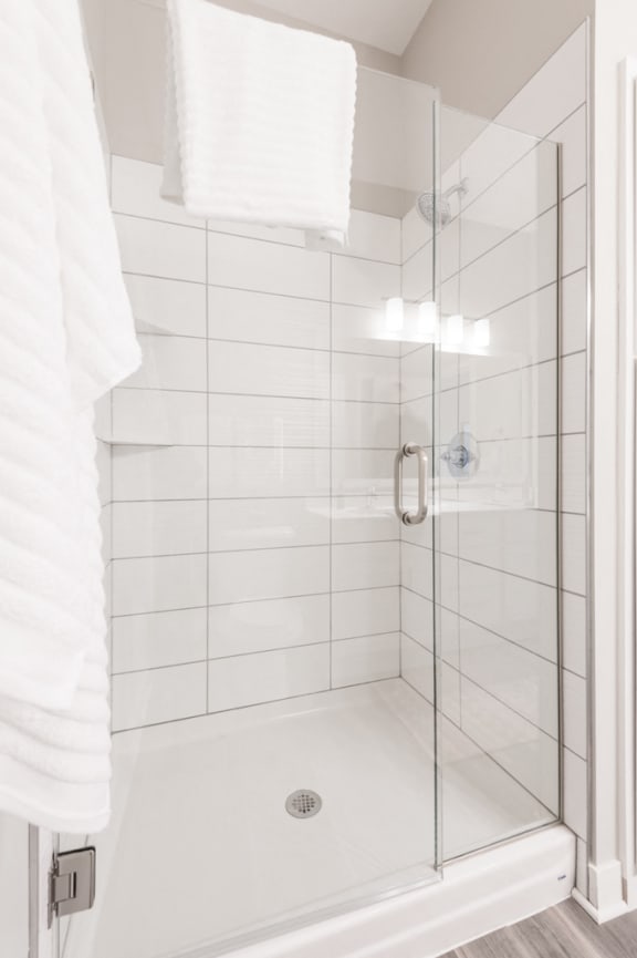 White tiled shower with glass door