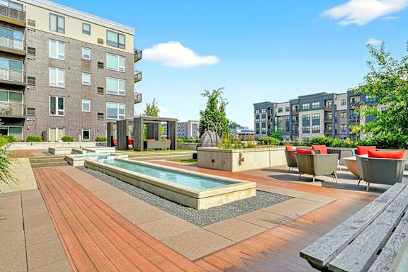 A spacious outdoor relaxation garden with a long water feature, shaded cabanas, and cozy seating areas.
