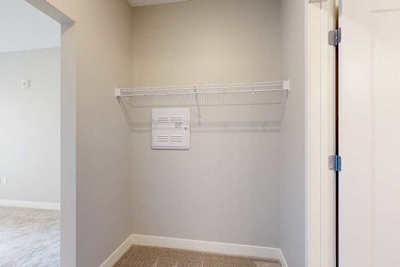 An oversized walk-through closet with built-in wire shelves.