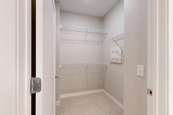 An oversized walk-in closet with several built-in wire shelves.