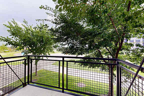 A balcony with a metal railing and a view of the neighborhood.