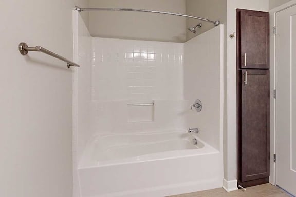 A bathroom with a tub shower and linen cabinets.