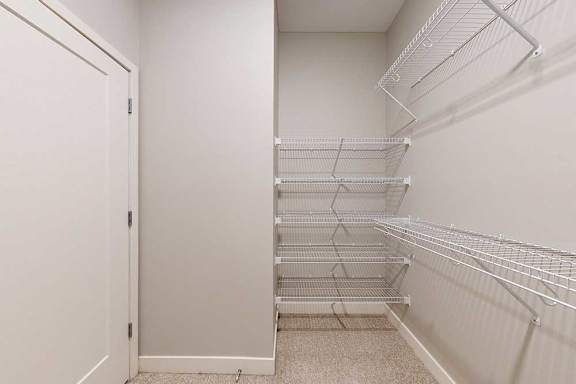 An oversized walk-in closet with several built-in wire shelves.