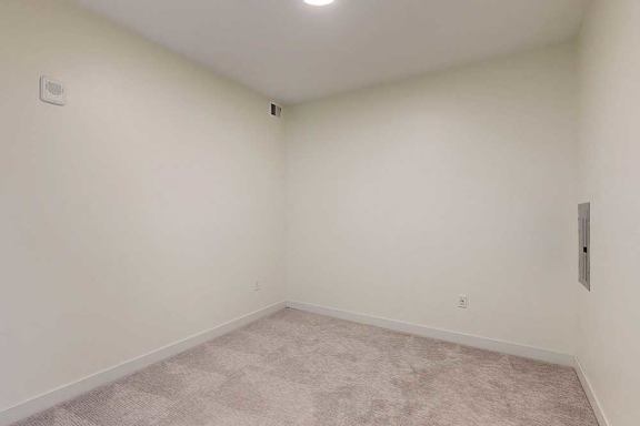A room with a carpeted floor and white walls.