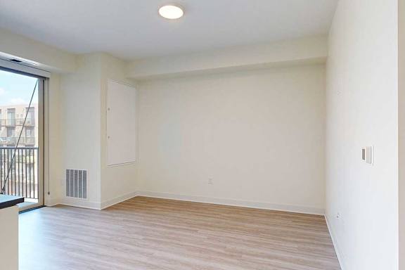 A living room with a sliding glass door and white walls