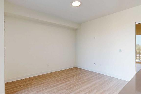 A living room with wooden flooring and white walls.