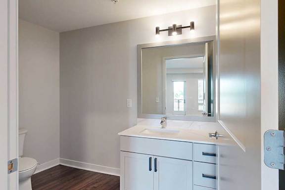 A bathroom with a white sink and a mirror above it.