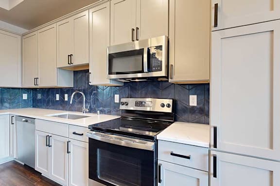 A kitchen with white cabinets and stainless steel appliances