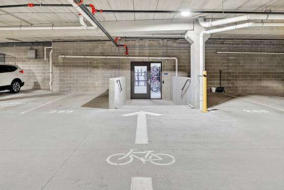 A parking garage with a bicycle lane and a charging station for electric vehicles.