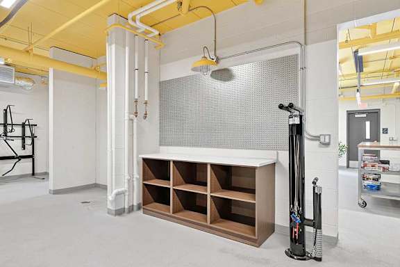 A room with a white wall and a yellow ceiling with a white pipe running along it.