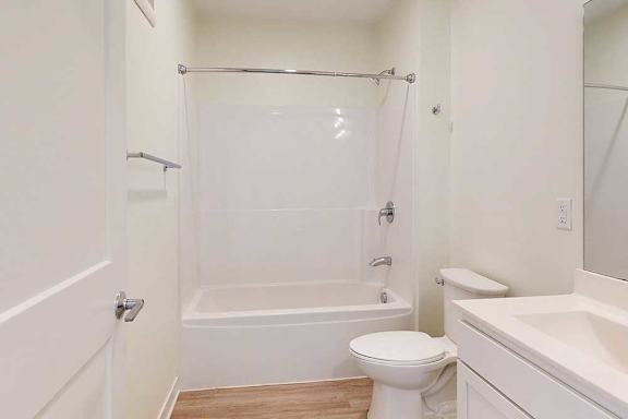 A white bathroom with a toilet, sink, and bathtub.