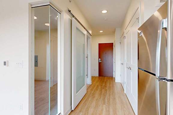 A long hallway with a refrigerator on the right.